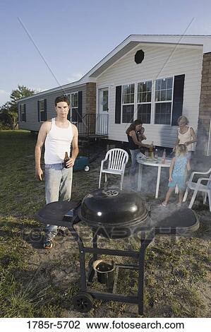 Blue collar families enjoying a cookout in front of trailer home View Large Photo Image Stock Image - Blue collar families enjoying a cookout in front of trailer home. Fotosearch