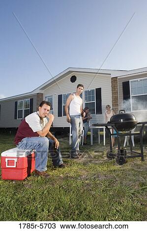 Blue collar families enjoying a cookout in front of trailer home View Large Photo Image Stock Image - Blue collar families enjoying a cookout in front of trailer home. Fotosearch