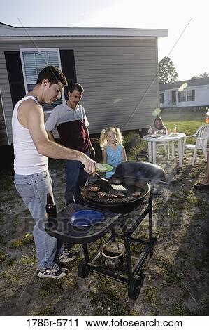 Blue collar families enjoying a cookout in front of trailer home View Large Photo Image Stock Image - Blue collar families enjoying a cookout in front of trailer home. Fotosearch