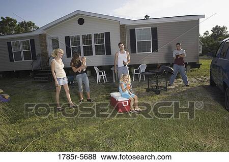 Blue collar families enjoying a cookout in front of trailer home View Large Photo Image Stock Photo - Blue collar families enjoying a cookout in front of trailer home. Fotosearch