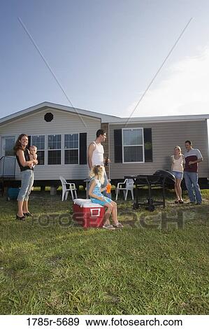 Blue collar families enjoying a cookout in front of trailer home View Large Photo Image Stock Photo - Blue collar families enjoying a cookout in front of trailer home. Fotosearch