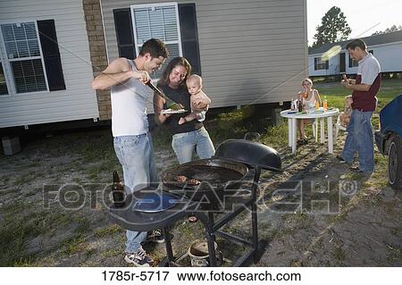 Blue collar families enjoying a cookout in front of trailer home View Large Photo Image Stock Photo - Blue collar families enjoying a cookout in front of trailer home. Fotosearch