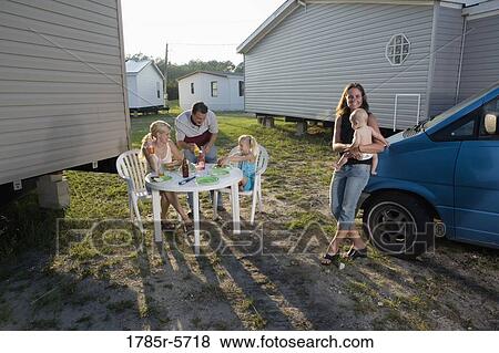 Blue collar families enjoying a cookout in front of trailer home View Large Photo Image Stock Photo - Blue collar families enjoying a cookout in front of trailer home. Fotosearch