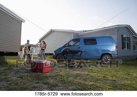 Blue collar families enjoying a cookout in front of trailer home View Large Photo Image Stock Photo - Blue collar families enjoying a cookout in front of trailer home. Fotosearch