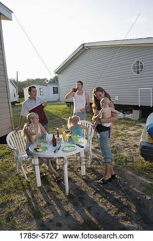 Blue collar families enjoying lunch in front of trailer home View Large Photo Image Stock Photo - Blue collar families enjoying lunch in front of trailer home. Fotosearch