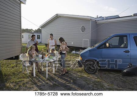 Blue collar families enjoying lunch in front of trailer home View Large Photo Image Stock Photo - Blue collar families enjoying lunch in front of trailer home. Fotosearch