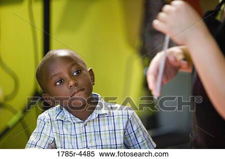 Boy (5-6) watching and listening attentively to his teacher View Large Photo Image Stock Photography - Boy (5-6) watching and listening attentively to his teacher. Fotosearch