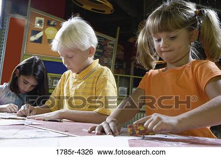 Boy and girls drawing in an art class View Large Photo Image Stock Photograph - Boy and girls drawing in an art class. Fotosearch