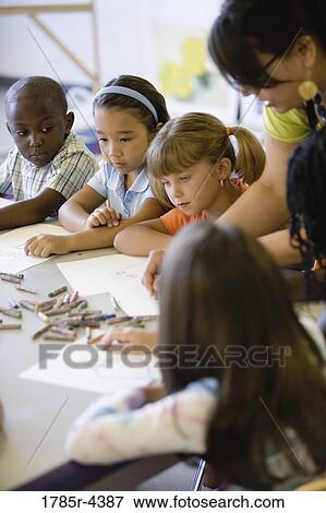 Boy and girls paying attention to teacher in an art class View Large Photo Image Stock Photo - Boy and girls paying attention to teacher in an art class. Fotosearch