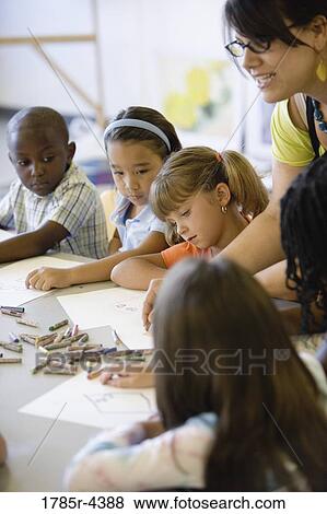 Boy and girls paying attention to teacher in an art class View Large Photo Image Stock Photo - Boy and girls paying attention to teacher in an art class. Fotosearch