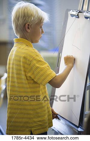 Boy drawing on easel View Large Photo Image Picture - Boy drawing on easel. Fotosearch