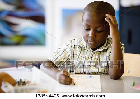 Boy drawing with crayon in art class View Large Photo Image Stock Photography - Boy drawing with crayon in art class. Fotosearch