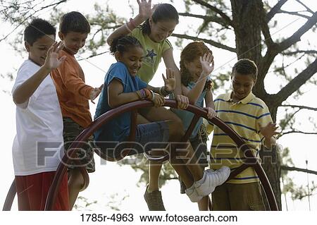Boys and girls climbing on monkey bars at a playground View Large Photo Image Stock Image - Boys and girls climbing on monkey bars at a playground. Fotosearch