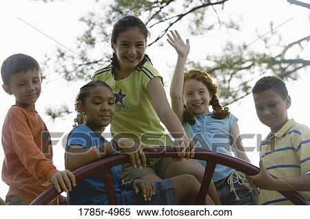 Stock Photography - Boys and girls climbing on monkey bars at a playground. Fotosearch