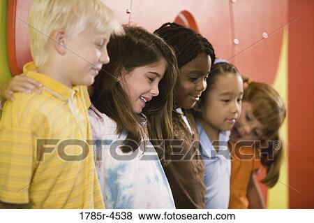 Stock Photo - Boys and girls posing and leaning against a colorful wall. Fotosearch