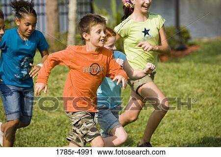 Boys and girls running side by side at a park View Large Photo Image Stock Image - Boys and girls running side by side at a park. Fotosearch
