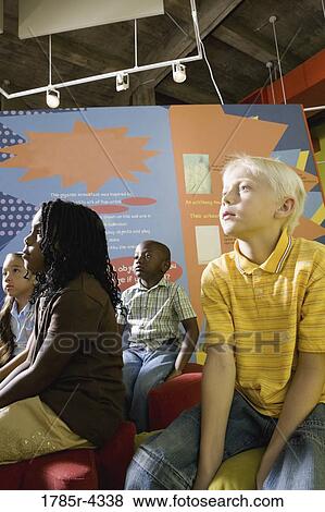 Boys and girls watching and listening attentively in a class View Large Photo Image Stock Photo - Boys and girls watching and listening attentively in a class. Fotosearch