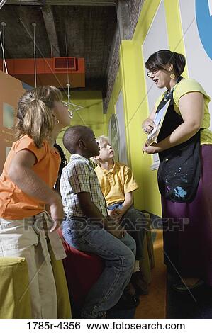 Boys and girls watching and listening attentively to their art teacher in an art class View Large Photo Image Stock Photograph - Boys and girls watching and listening attentively to their art teacher in an art class. Fotosearch