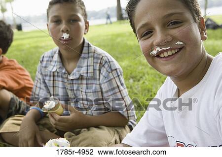 Boys eating cupcakes at a park View Large Photo Image Stock Image - Boys eating cupcakes at a park. Fotosearch