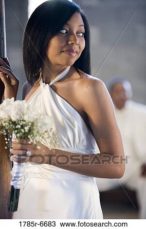 Bride holding a white bouquet with groom in background View Large Photo Image Stock Image - Bride holding a white bouquet with groom in background. Fotosearch