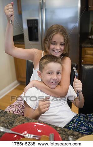 Brother and sister playing in kitchen View Large Photo Image Stock Photo - Brother and sister playing in kitchen. Fotosearch