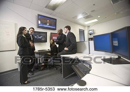 Stock Image - Business colleagues having a discussion in the office. Fotosearch