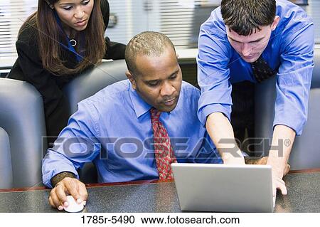 Business colleagues using laptop in a conference room View Large Photo Image Stock Image - Business colleagues using laptop in a conference room. Fotosearch