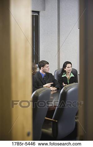 Business executives meeting in a conference room viewed through a door View Large Photo Image Stock Photograph - Business executives meeting in a conference room viewed through a door. Fotosearch