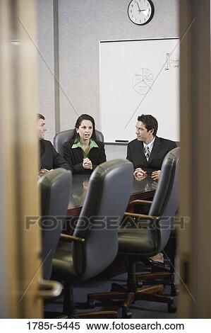 Business executives meeting in a conference room viewed through a door View Large Photo Image Stock Photography - Business executives meeting in a conference room viewed through a door. Fotosearch