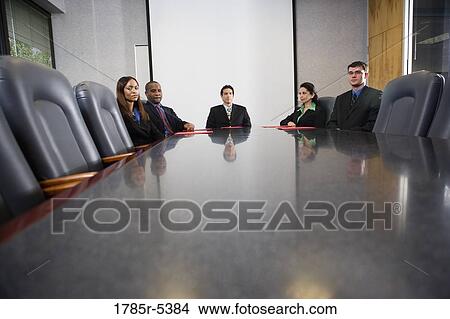 Business executives sitting together in a formal conference room View Large Photo Image Picture - Business executives sitting together in a formal conference room. Fotosearch
