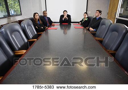 Business executives sitting together in a formal conference room View Large Photo Image Stock Image - Business executives sitting together in a formal conference room. Fotosearch