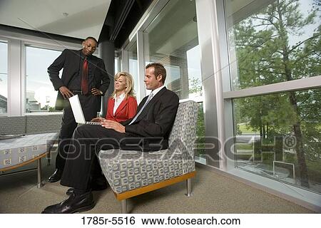 Stock Photograph - Business executives working together on laptop. Fotosearch