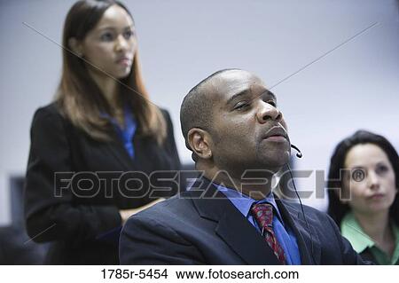 Business man and women watching and listening attentively View Large Photo Image Picture - Business man and women watching and listening attentively. Fotosearch