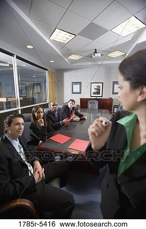 Stock Photograph - Business men and women at a presentation in a formal conference room. Fotosearch