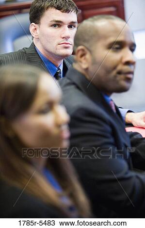 Business men and women watching and listening attentively in a meeting View Large Photo Image Stock Image - Business men and women watching and listening attentively in a meeting. Fotosearch