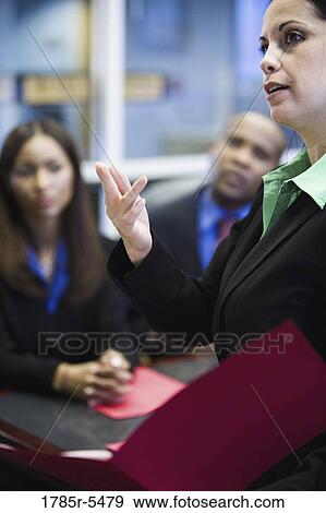 Business men and women watching and listening attentively in a meeting View Large Photo Image Stock Photo - Business men and women watching and listening attentively in a meeting. Fotosearch
