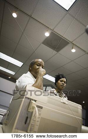 Stock Photography - Business people standing next to copier. Fotosearch