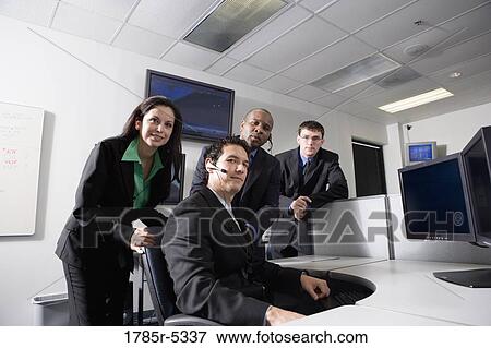 Stock Photo - Business people working in a busy office. Fotosearch