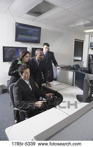 Stock Photo - Business people working in a busy office. Fotosearch
