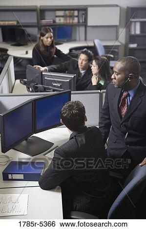 Stock Photograph - Business people working in a busy office. Fotosearch