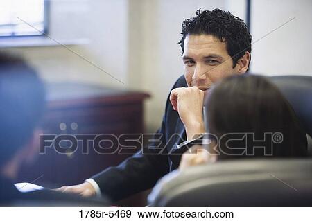 Business watching and listening to his colleagues View Large Photo Image Stock Photo - Business watching and listening to his colleagues. Fotosearch