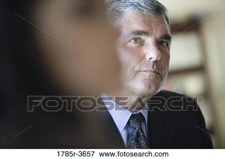 Businessman and woman sitting in office View Large Photo Image Stock Photo - Businessman and woman sitting in office. Fotosearch