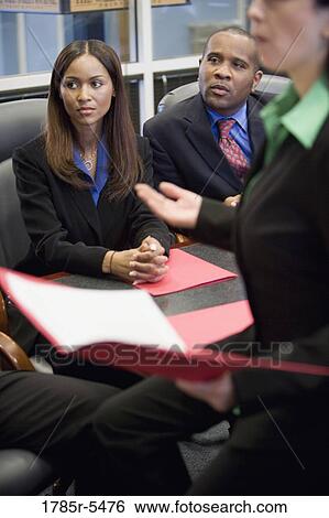 Businessman and women watching and listening attentively in a meeting View Large Photo Image Stock Photograph - Businessman and women watching and listening attentively in a meeting. Fotosearch