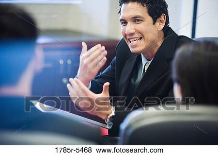 Businessman forcefully gesturing towards his colleagues View Large Photo Image Stock Photo - Businessman forcefully gesturing towards his colleagues. Fotosearch