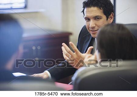Businessman gesturing towards his colleagues View Large Photo Image Stock Image - Businessman gesturing towards his colleagues. Fotosearch
