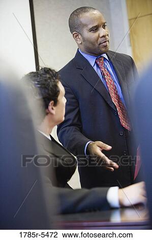 Stock Image - Businessman speaking to his colleagues. Fotosearch