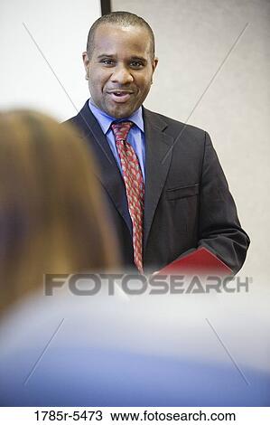 Businessman speaking to his colleagues View Large Photo Image Stock Image - Businessman speaking to his colleagues. Fotosearch
