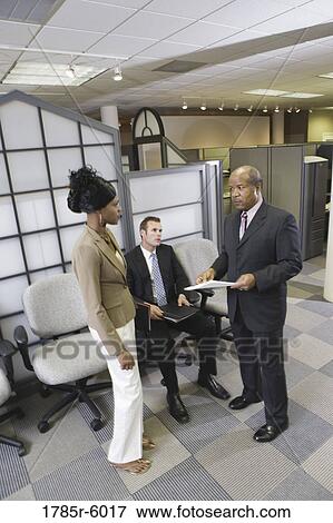 Businesspeople conversing in office waiting area View Large Photo Image Stock Photo - Businesspeople conversing in office waiting area. Fotosearch