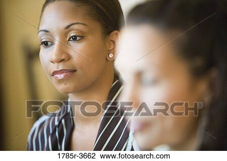 Businesswomen conversing in office View Large Photo Image Stock Image - Businesswomen conversing in office. Fotosearch