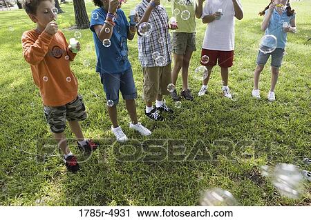 Children and blowing bubbles at a park View Large Photo Image Stock Image - Children and blowing bubbles at a park. Fotosearch
